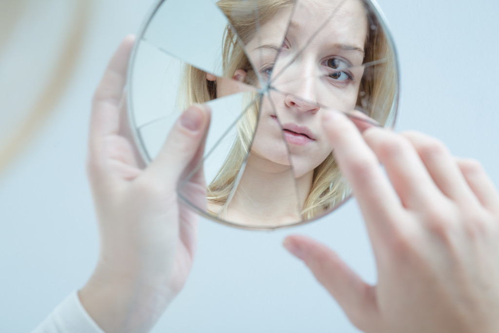woman looking at a broken mirror