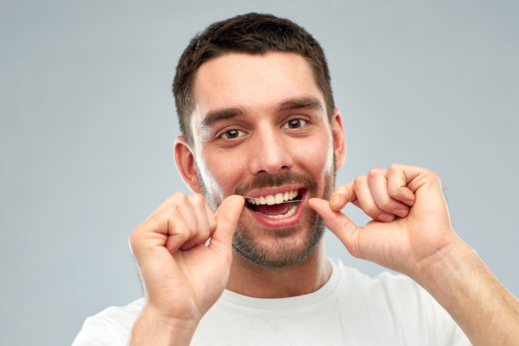 Guy using dental floss