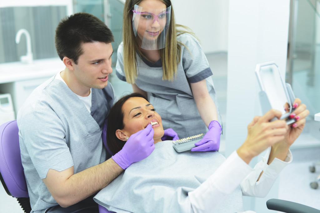 a dentist placing a fake tooth in a woman's teeth