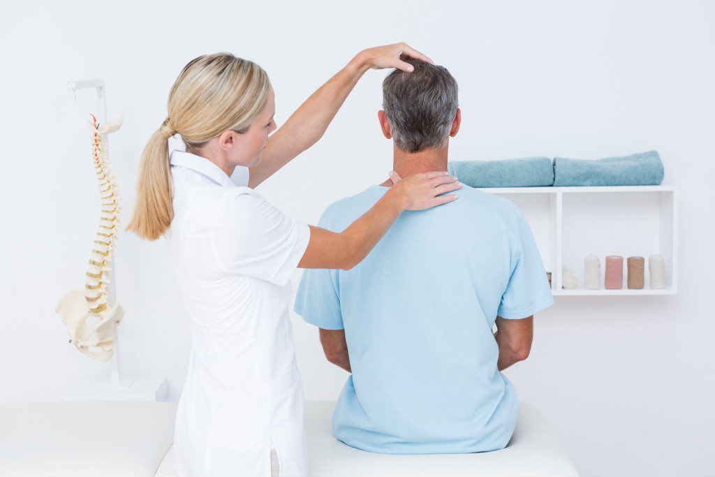a female chiropractor with a male patient in her office
