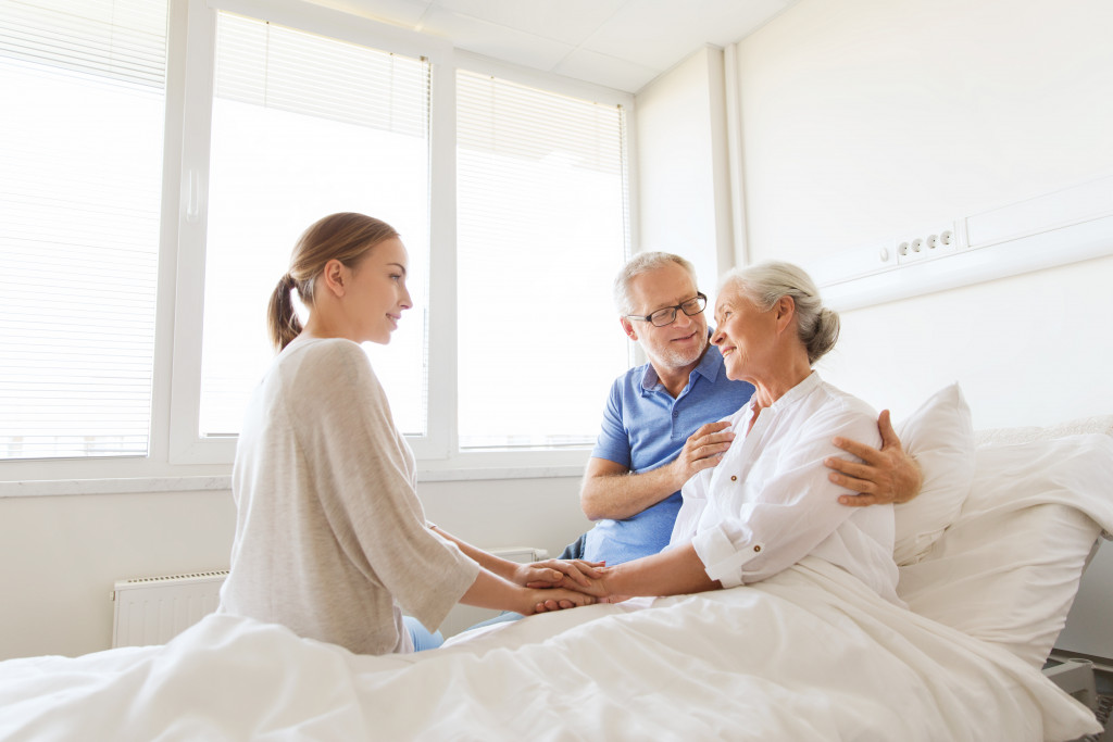 a daughter talking to her elderly parents on bed