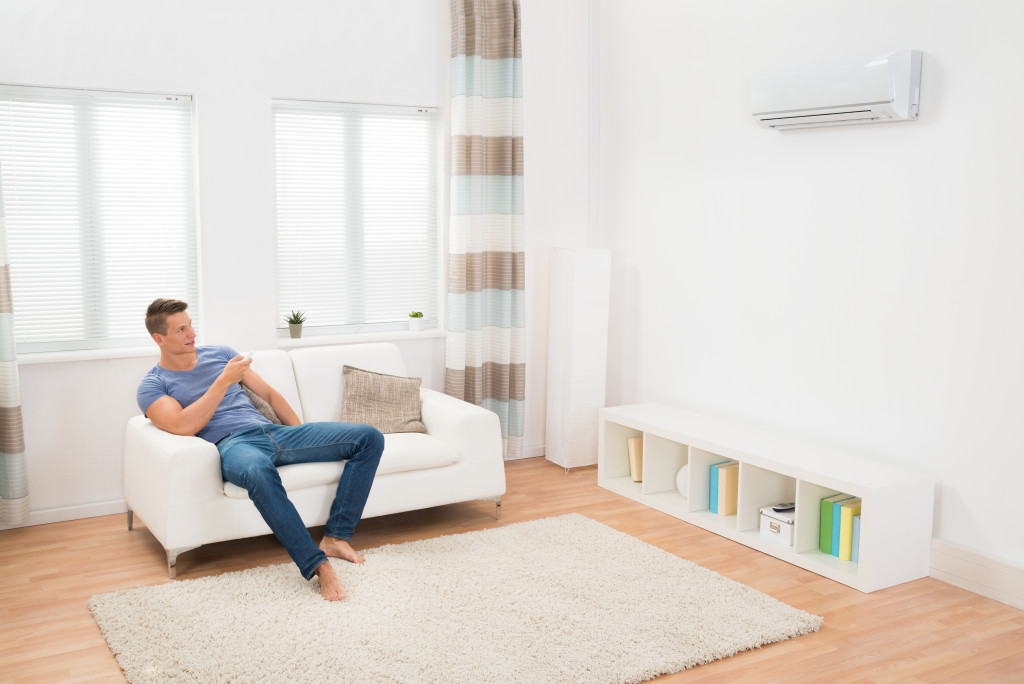 man holding the remote for air conditioner