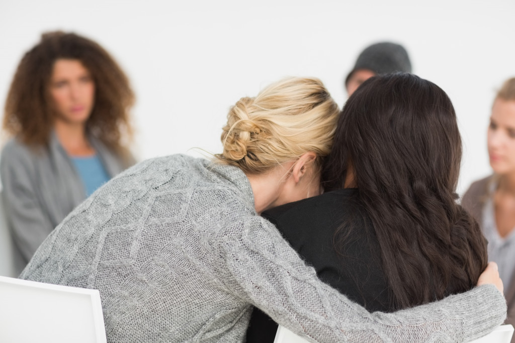 A woman hugging another woman in a therapy session