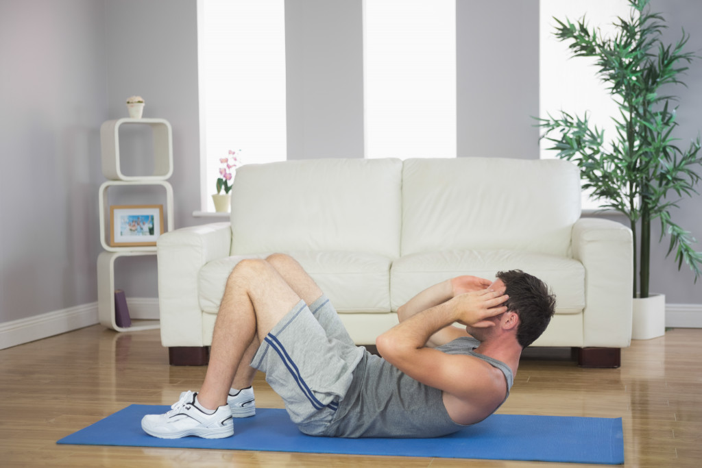 A fit man doing sit ups in a home living room