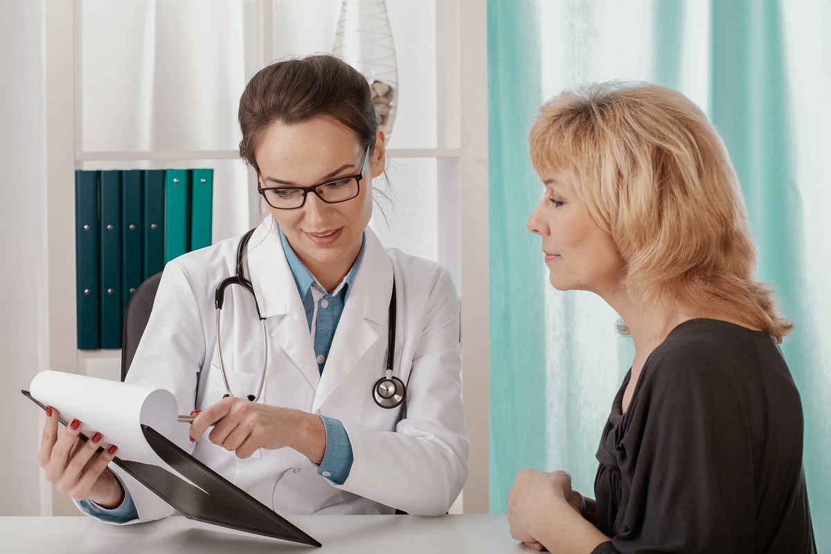 doctor showing medical records to her senior patient